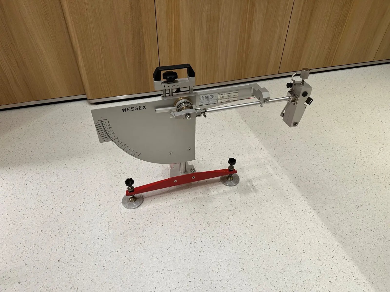 A Wessex pendulum slip resistance tester set up on a light terrazzo floor